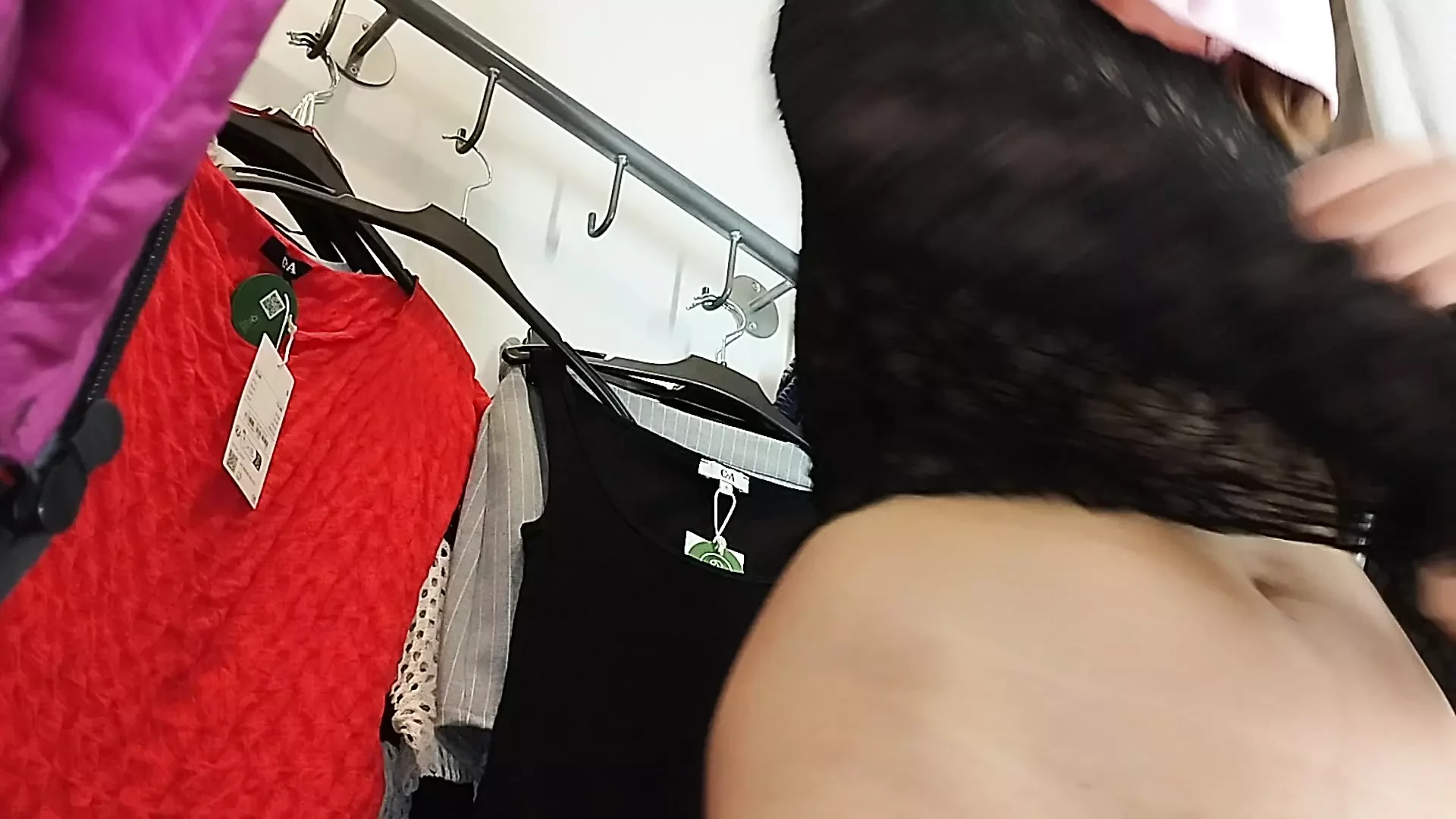 Wanita seksi mencoba pakaian telanjang di ruang pas.