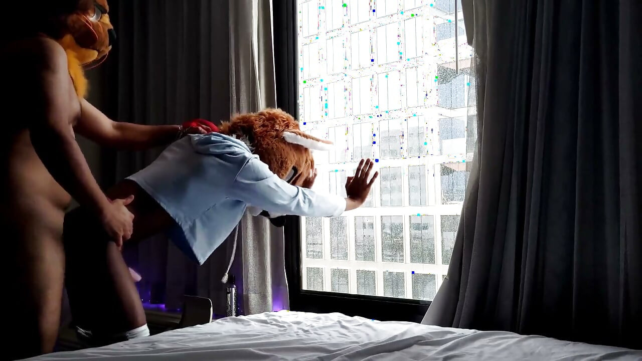 窓の前で裸のフェムボーイのファースーツのセックス