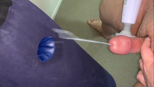 Kleiner Penis mit vibrierendem Massagegerät, das eine Ladung auf ein aufblasbares Kissen schießt