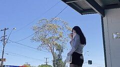 Crossdresser asiático con medias en la parada de autobús