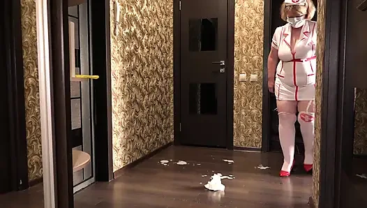 Sahnekuchen Unter Dem Bademantel Einer Reifen Krankenschwester. Dicker in Medizinischer Uniform Räumt Abseits Des Bildes Auf.