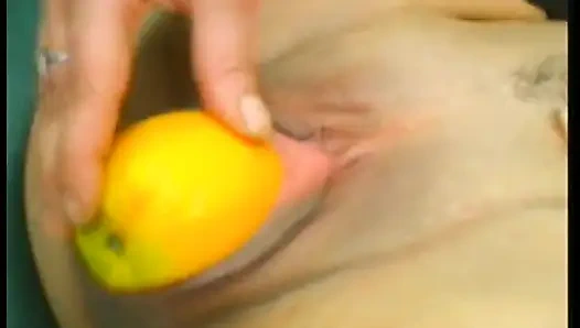 Pelacur dewasa berambut cokelat memakai stoking sambil mengebor lubangnya dengan makanan dan lilin besar