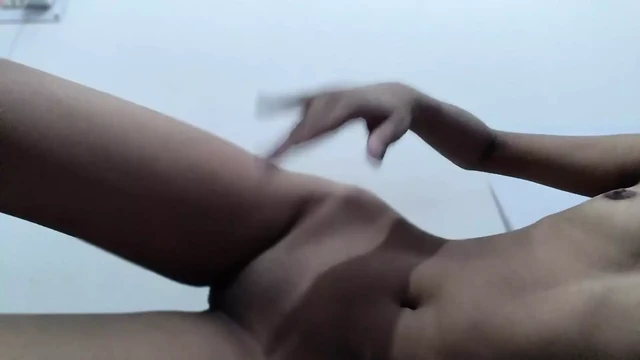 A girl masturbates on the bed with her fingers and brings herself to orgasm