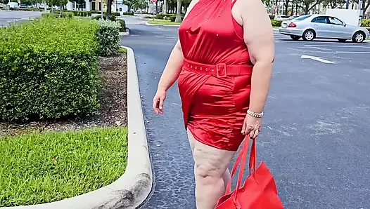Wanita cantik berjalan di luar ruangan di tempat parkir umum pamer untuk orang asing