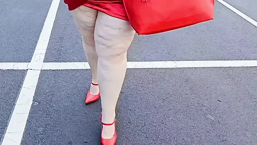 Wanita cantik berjalan di luar ruangan di tempat parkir memamerkan diri untuk orang asing