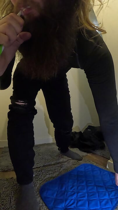 Inundando jeans pretos e meias com xixi enquanto escova os dentes