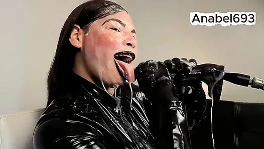 Ein Dämon in Latex, Latexhandschuhen, einem Latexanzug und schwarzen lippen lutscht sinnlich deinen schwanz und spuckt Speichel und Sperma auf mich