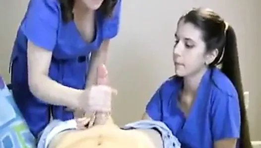 Duas enfermeiras ordenham seu paciente