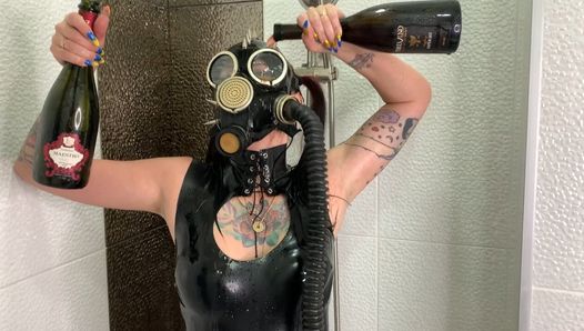 Dominatrix Nika com uma máscara de gás derrama vinho sobre seu corpo de látex. Fetiche por látex