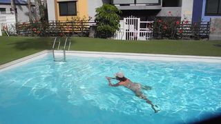 Erwachsene Frau, die nackt im Pool badet