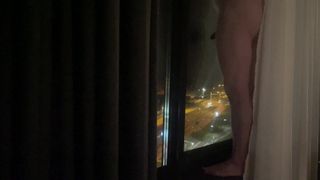 Naakt voor het hotel raam