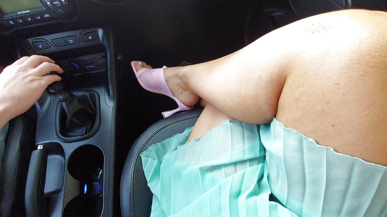 Een aantrekkelijke en elegante milf met sexy benen op hoge hakken en een kort rokje, in een taxi, 's ochtends