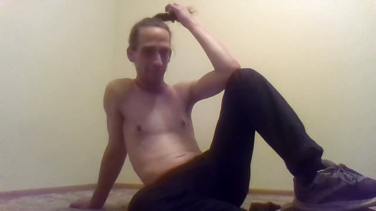 Une trans aux seins nus se brosse les cheveux