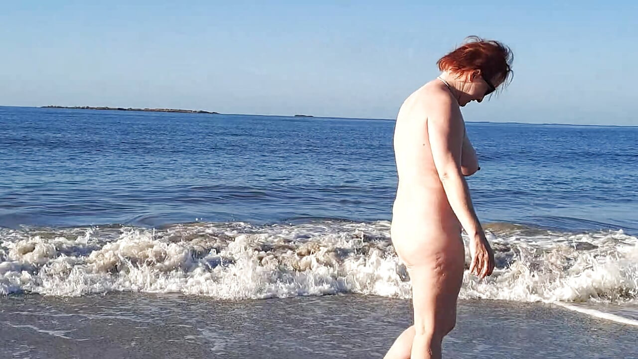 Pravi nudista se igra gola na okeanskom talasu