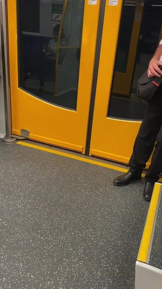 Alter großer Typ mit dem Schnurrbart am Bahnhof