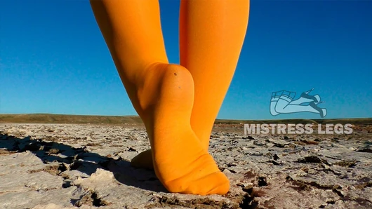 Barefoot walking by dried up lake in yellow pantyhose