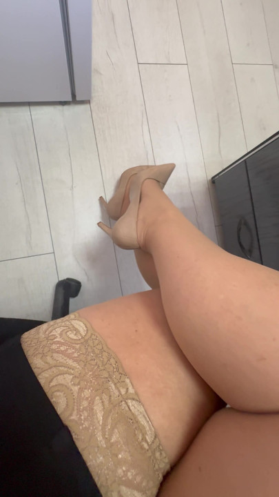 Ofiste yüksek topuklu ve naylon çoraplı olgun kadınlar