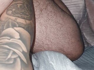 Madrastra tatuada acostada desnuda con la mano en la polla del hijastro