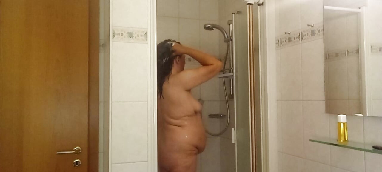 Real woman showering soft belly, wet skin