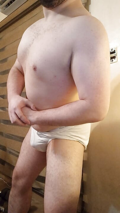 Muscular stud plays with his bulge and nipples