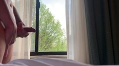 ホテルの部屋の窓で固いちんぽをしごく。