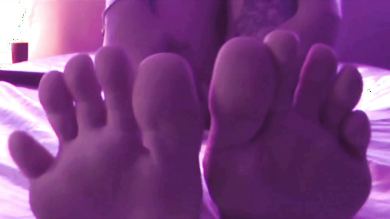Young Girl Using Her Feet to Play with the Dildo While Masturbating