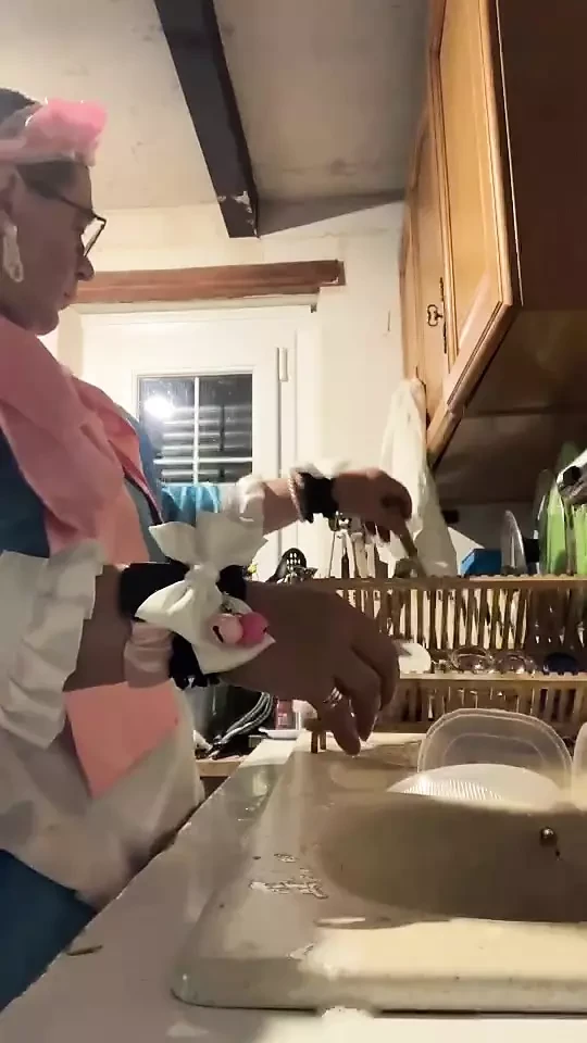 In a blue maid's outfit with pink bows to do the dishes.