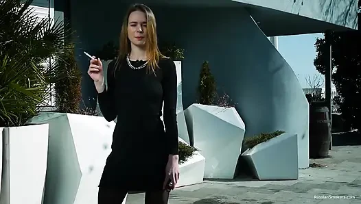 Genç Rus kız deniz kenarında sigara içiyor
