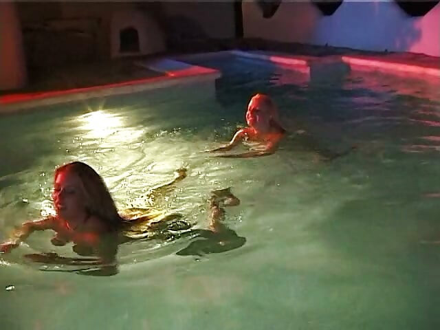 Dos chicas lesbianas sexys nadan juntas en la piscina