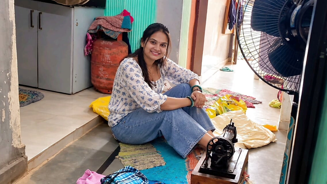 Indian wife sewing on the machine but she has other thoughts too.