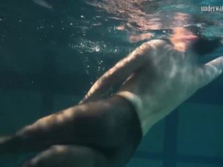 Geklede onderwaterschoonheid Bulava Lozhkova naakt zwemmend