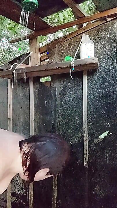 I'm watching a curvy girl wash herself in the street.