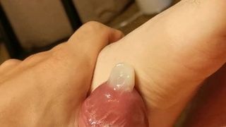 Descuidado con una mano trabajando con el pie con un condón