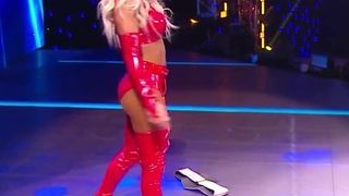 WWE - Carmella in red outfit standing over Sasha Banks