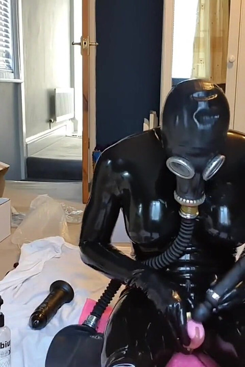 ラテックスドールの小さなピンクの貞操帯トレーニング、ガスマスク越しに呼吸