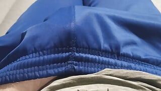 Un mec en pantalon de survêtement bleu se caresse la bosse