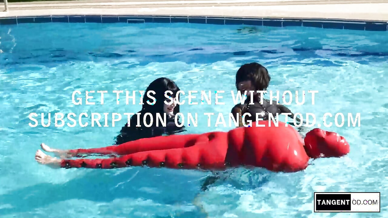TANGENTOD Women in Black Catsuits Float Red Latex Encased Figure on Inflatable Rubber Pool Toy