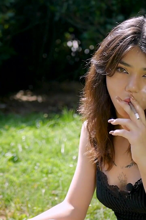 Arina Is Smoking One Black Cigarette Outdoors