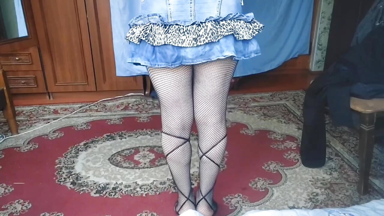 Linda femboy con suéter de gran sobre las piernas desnudas