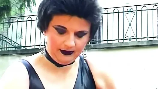 Brunette dominatrix menyematkan jepitan baju di kontol