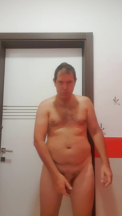 A boy completely naked in a station bathroom