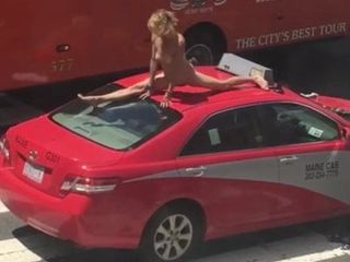 Donna che balla su una macchina in una strada trafficata