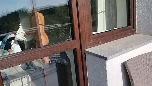 cizinec se dívá na nahou ženu z balkónu v hotelu, masturbuje, vyjde k němu a pomáhá mu