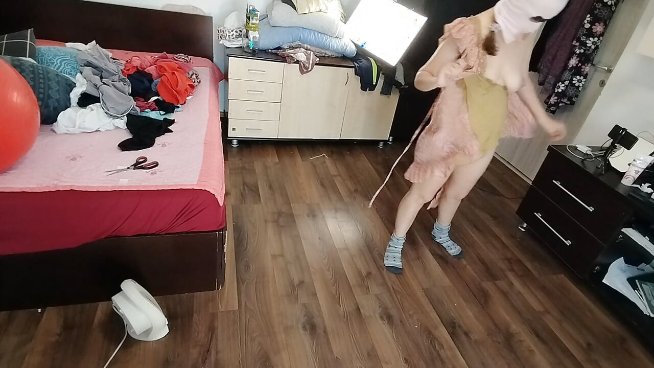 Amateur woman has fun trying on clothes and cutting them.