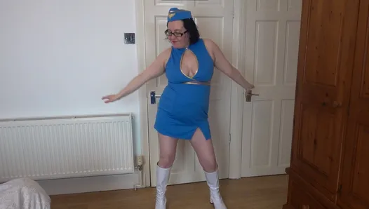 Une hôtesse de l’air sexy fait un strip-tease dans des bottes de genou en PVC blanc