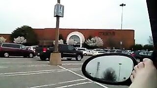 Un chat poilu joue et squirte dans une voiture dans le parking du centre commercial