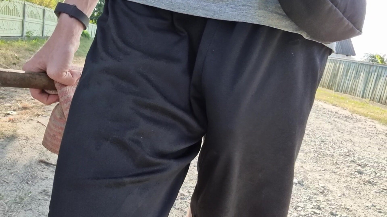 A large penis is visible from under his clothes while walking