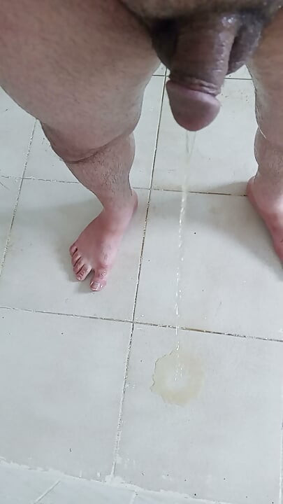 Fac pipi pe podeaua din baie, apoi mă așez pe pipi și încep să mă masturbez