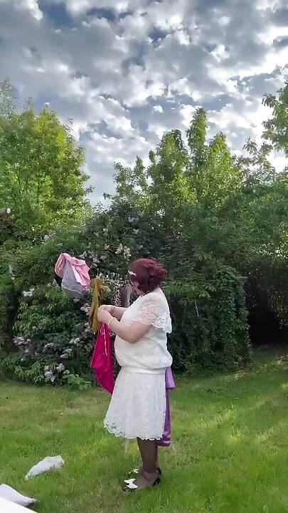 Dressed in a white lace dress to hang the laundry