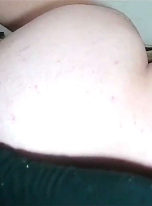 Feminine Girl Lying on Her Side Inserting the Dildo.